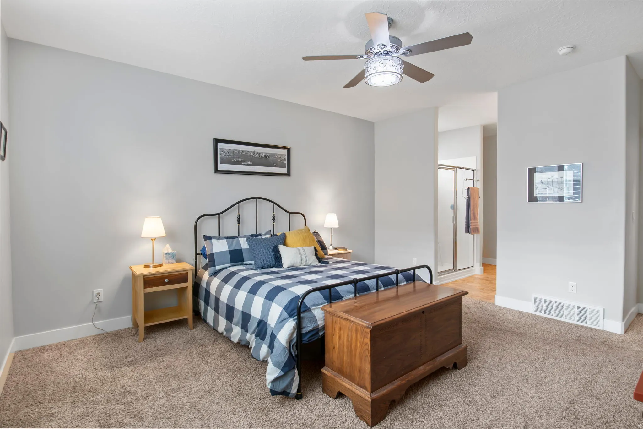 Bedroom featuring light colored carpet, ceiling fan, and connected bathroom