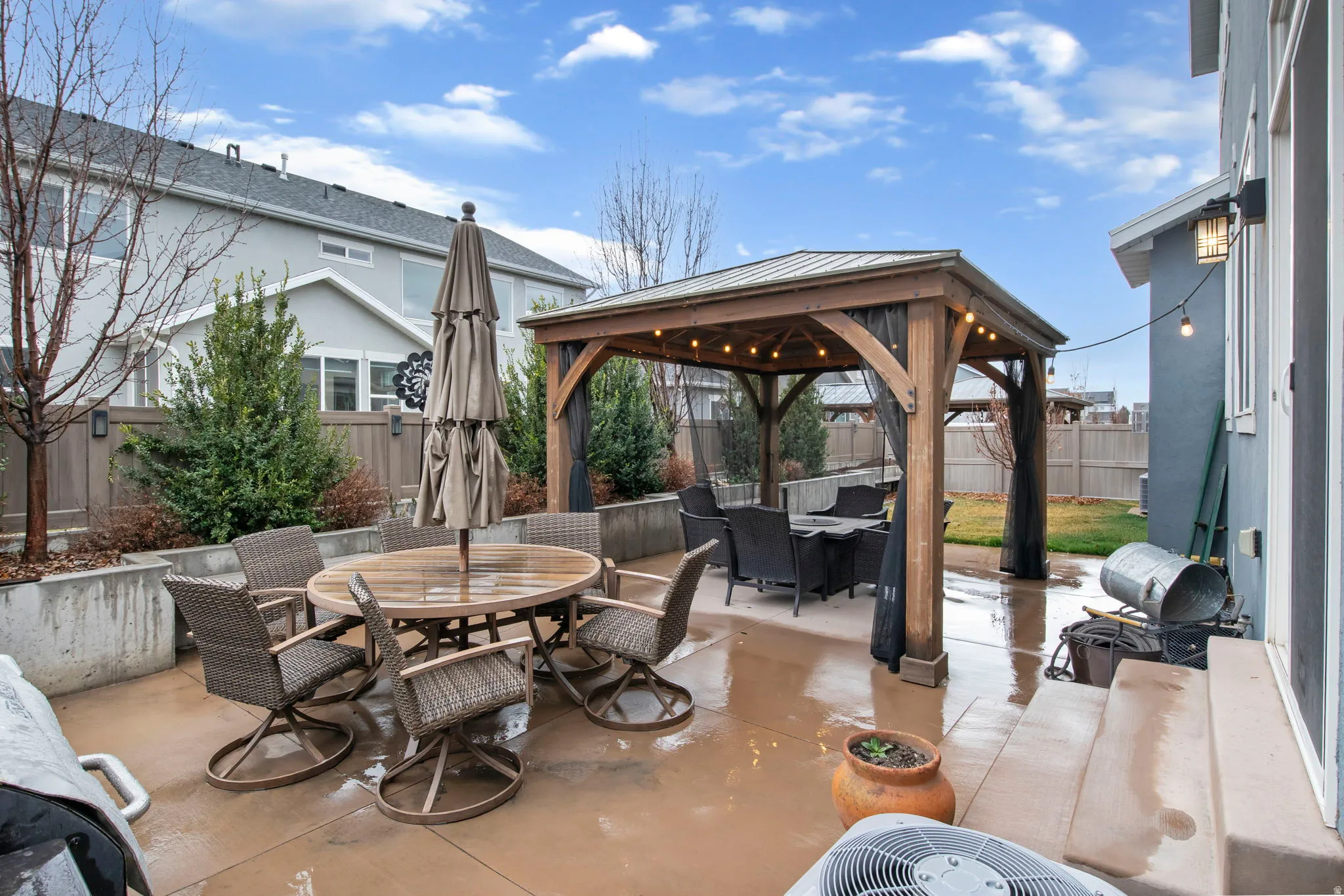 Fenced backyard featuring a gazebo, outdoor dining area, and a patio area