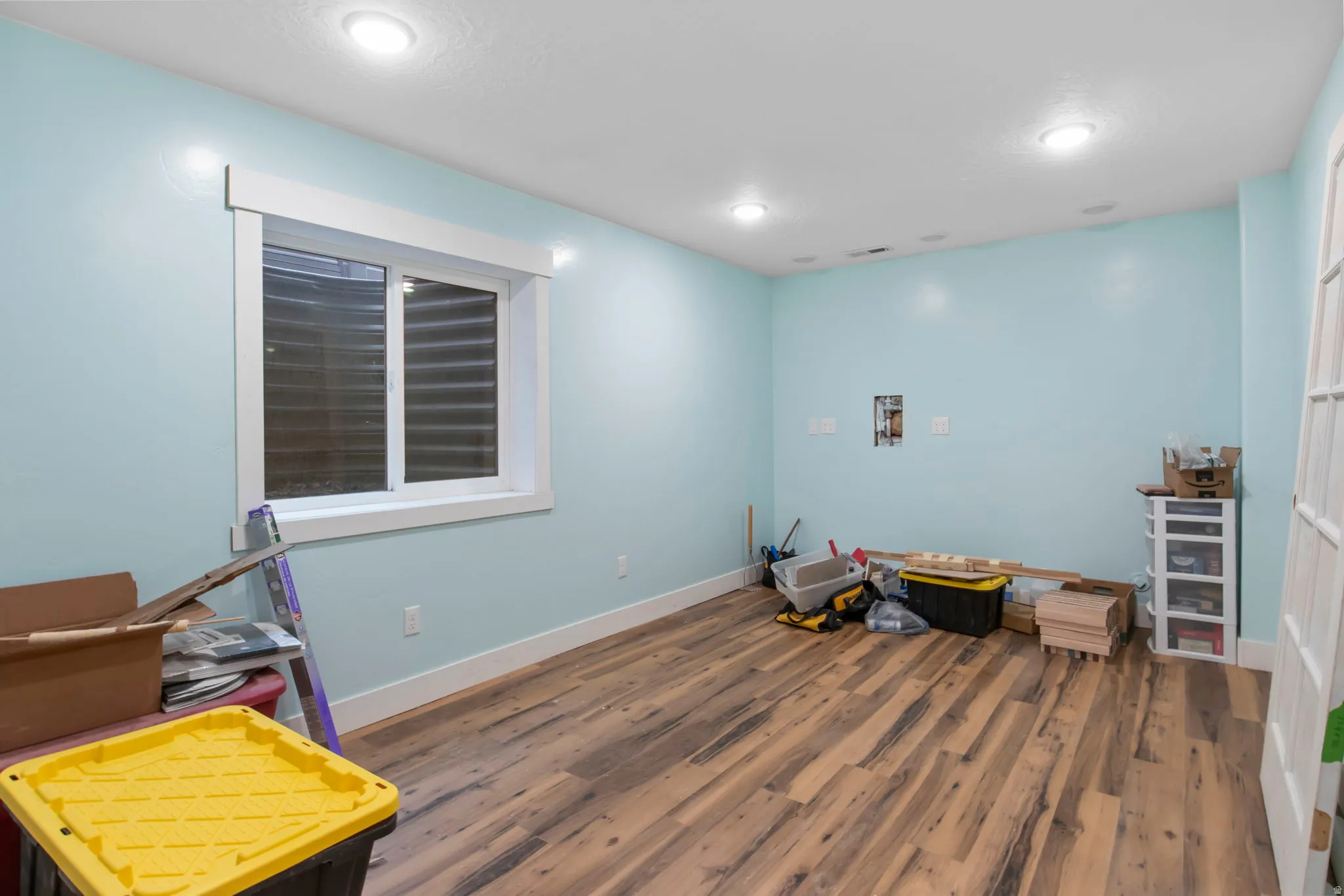 Miscellaneous room featuring dark wood-style flooring and baseboards