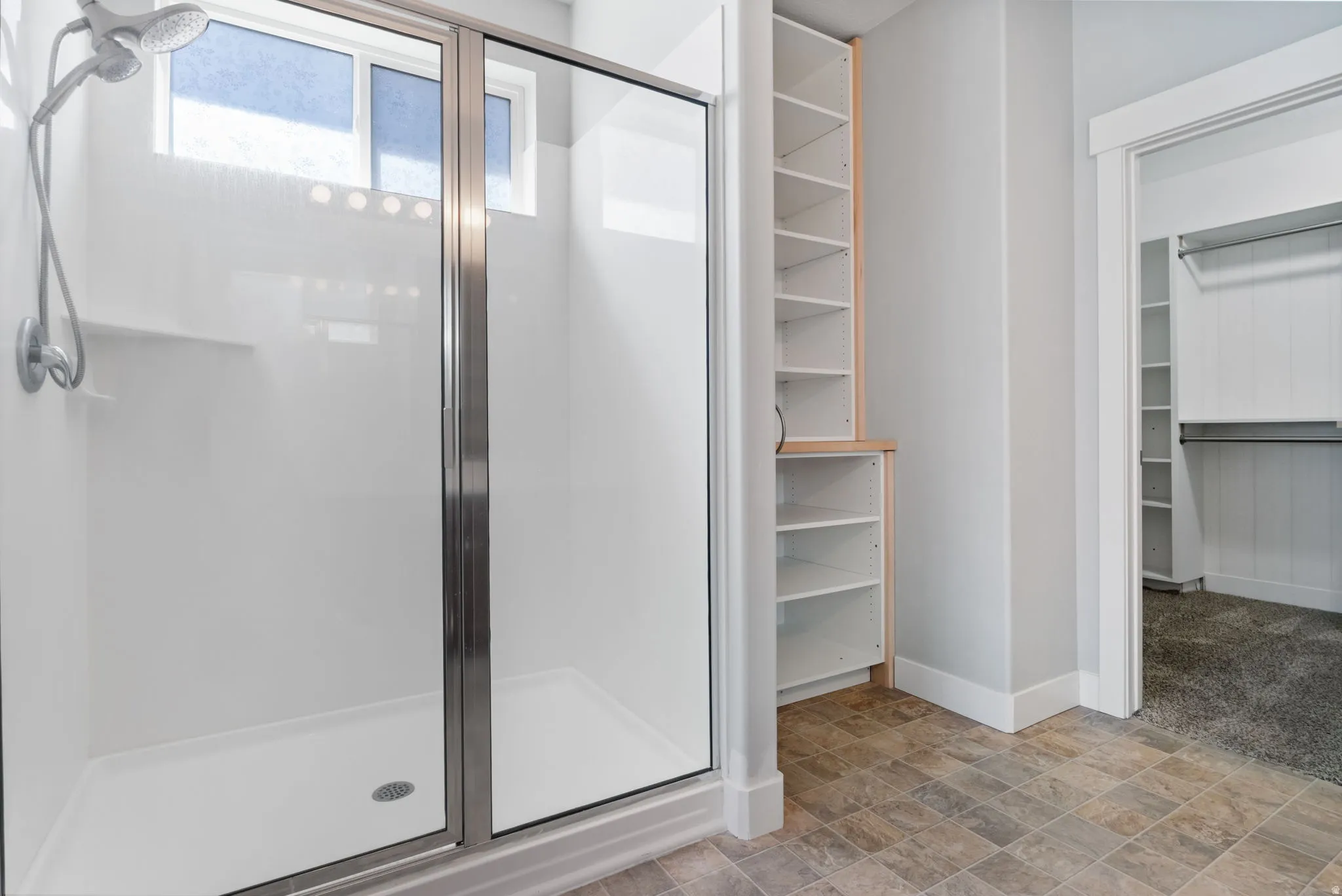 Enclosed shower with a glass door and window for natural light