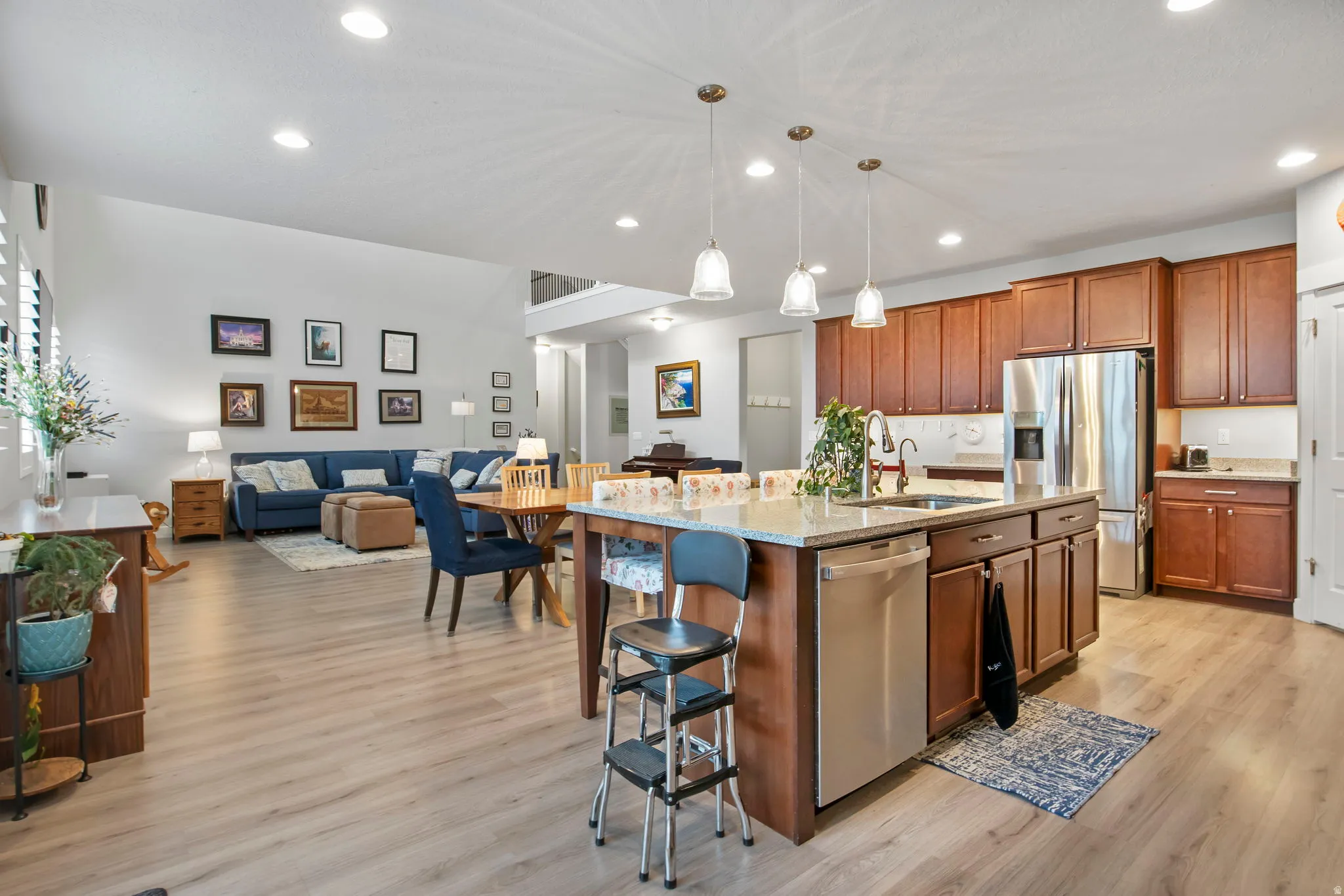 Kitchen with open floor plan, a kitchen breakfast bar, stainless steel appliances, and light wood-type flooring