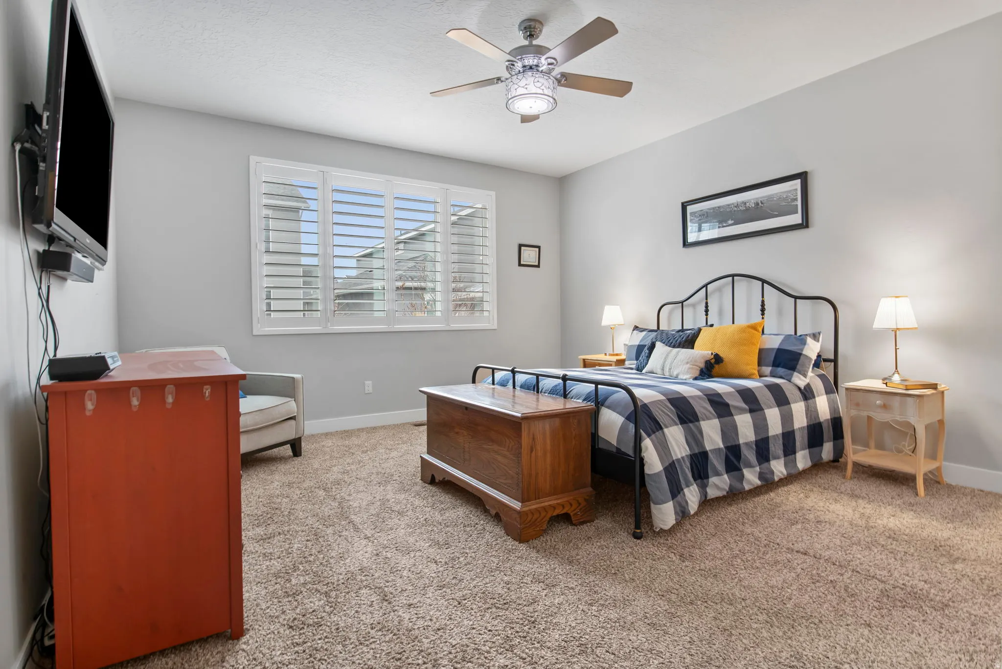 Bedroom with light carpet and a ceiling fan