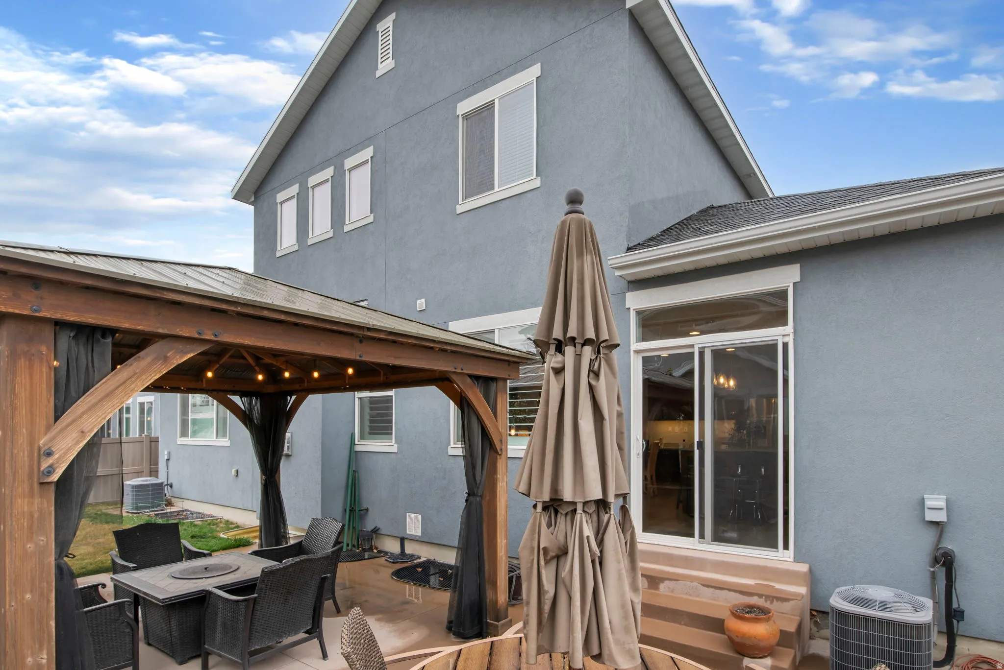 Wooden terrace featuring a gazebo and a patio