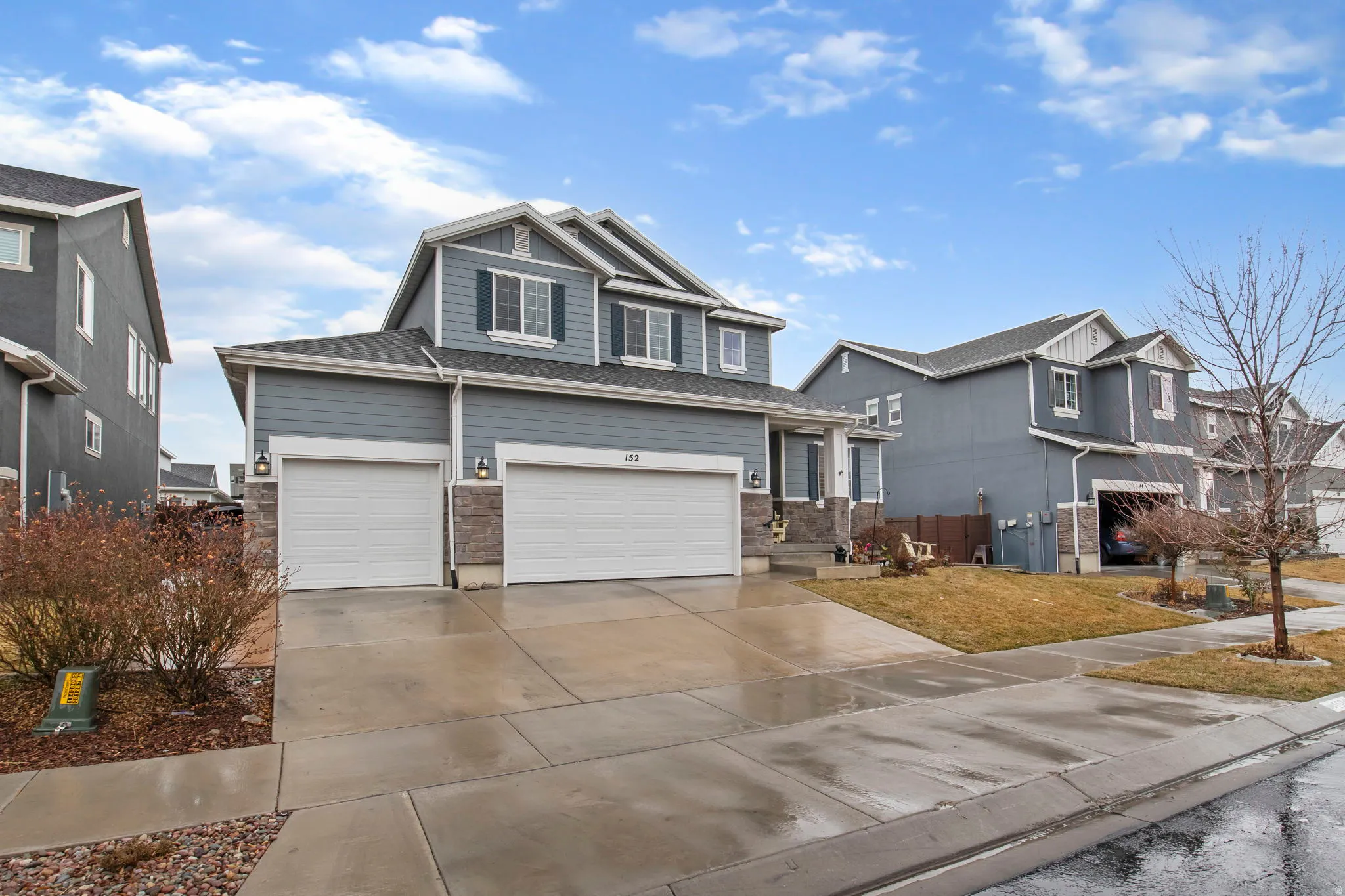 Craftsman-style home with concrete driveway, an attached garage, and a front yard