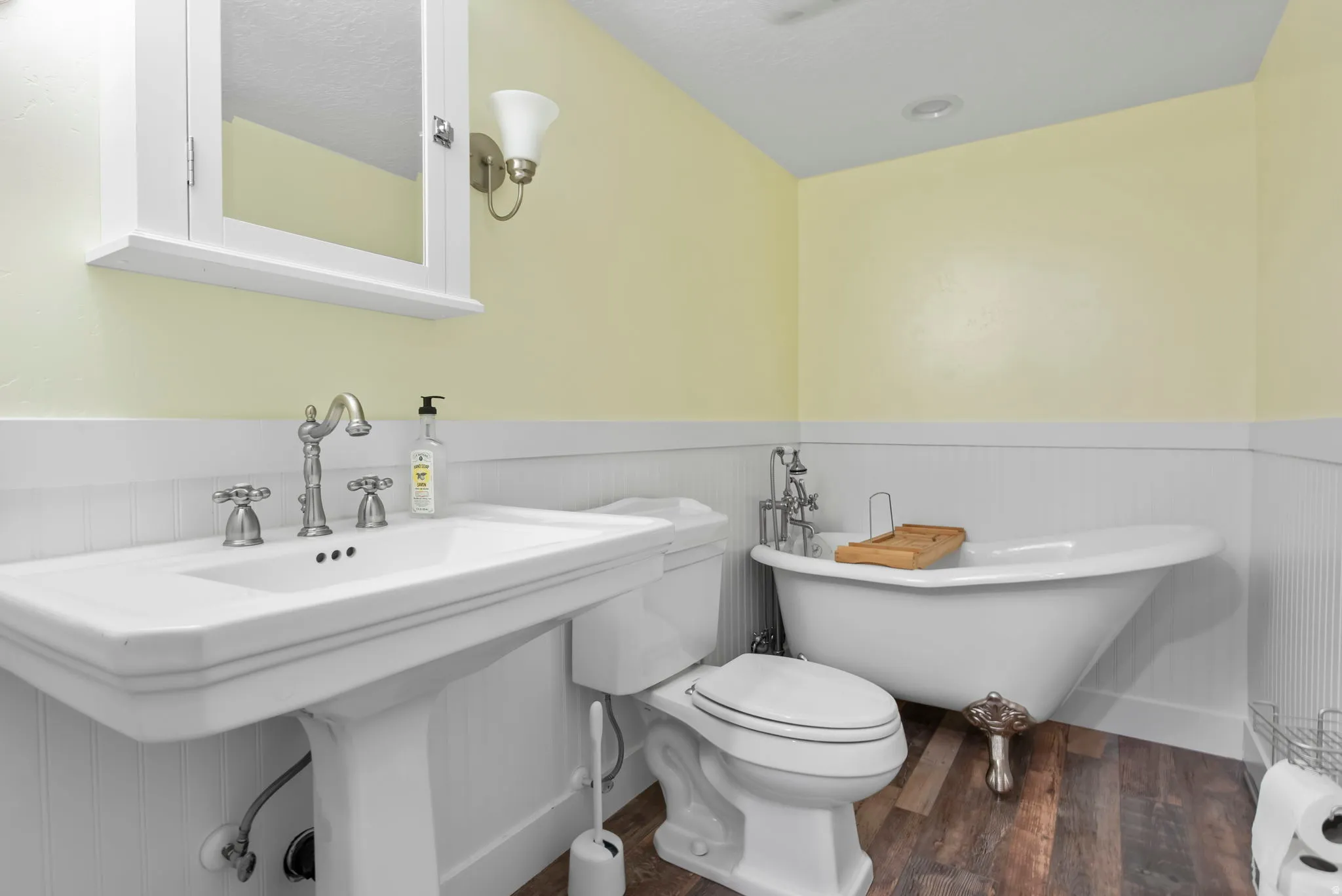 Full bathroom with wainscoting, dark wood finished floors, and a freestanding bath