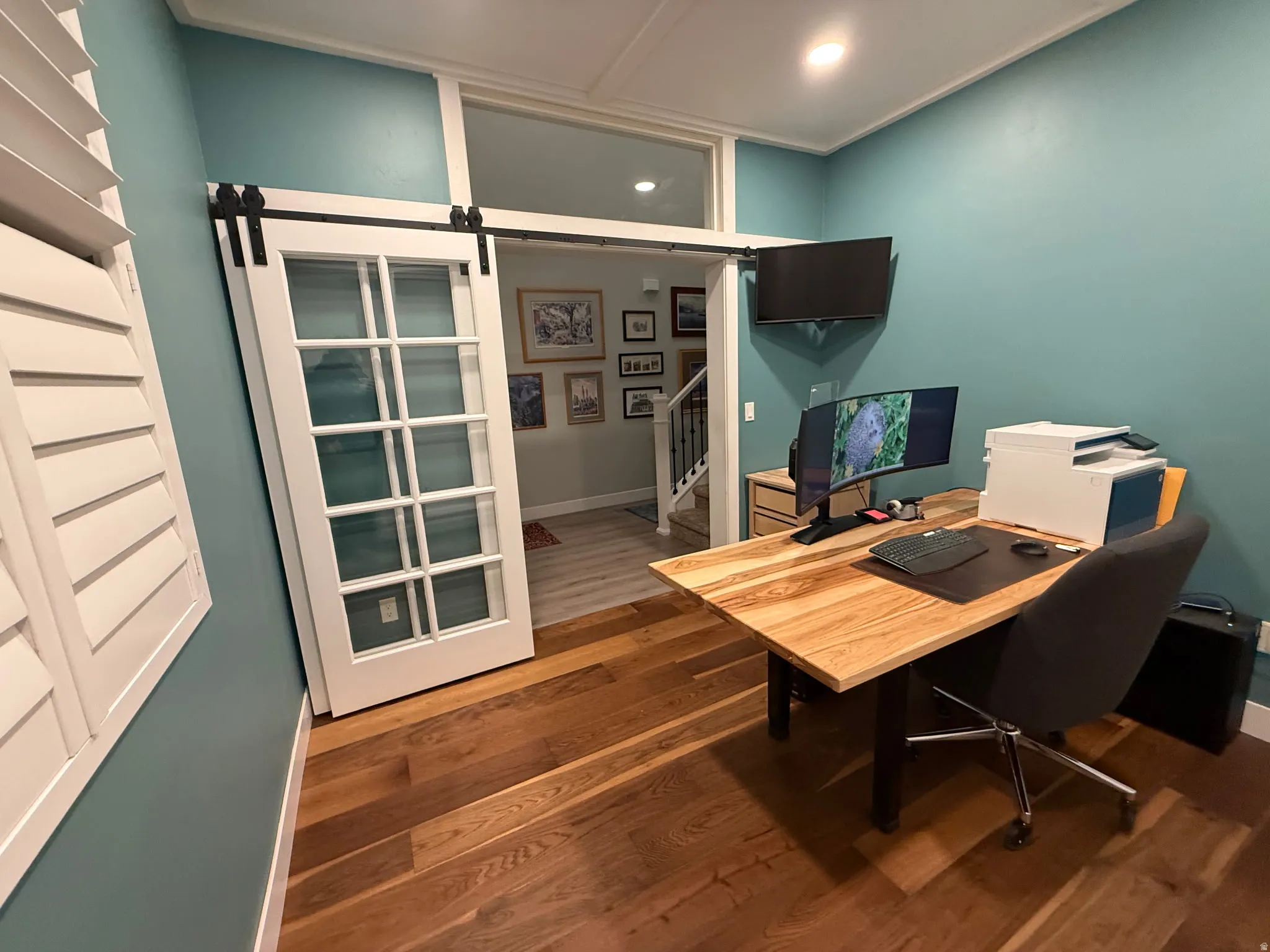 Office featuring a barn door and dark wood finished floors