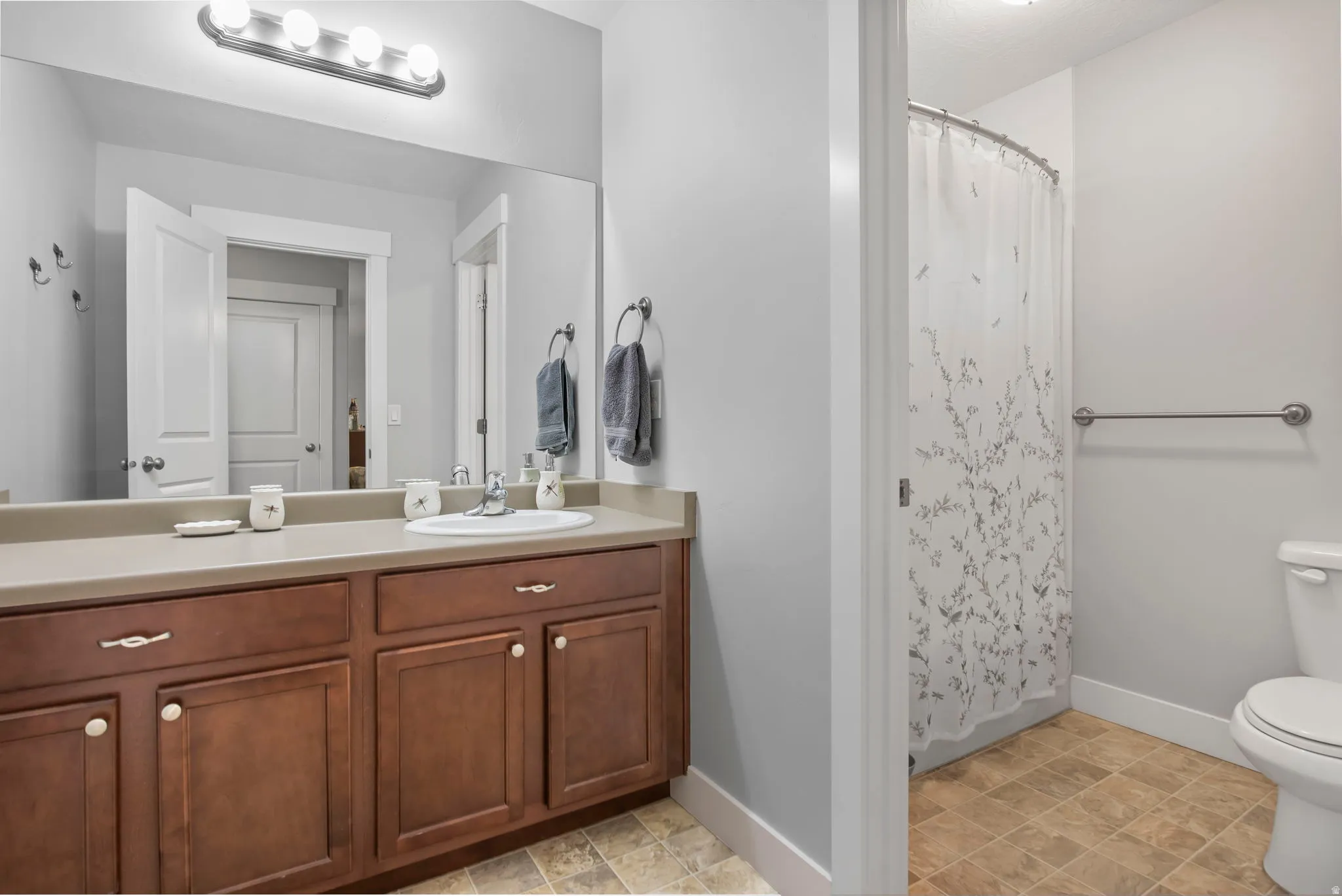 Bathroom featuring a shower with shower curtain and vanity