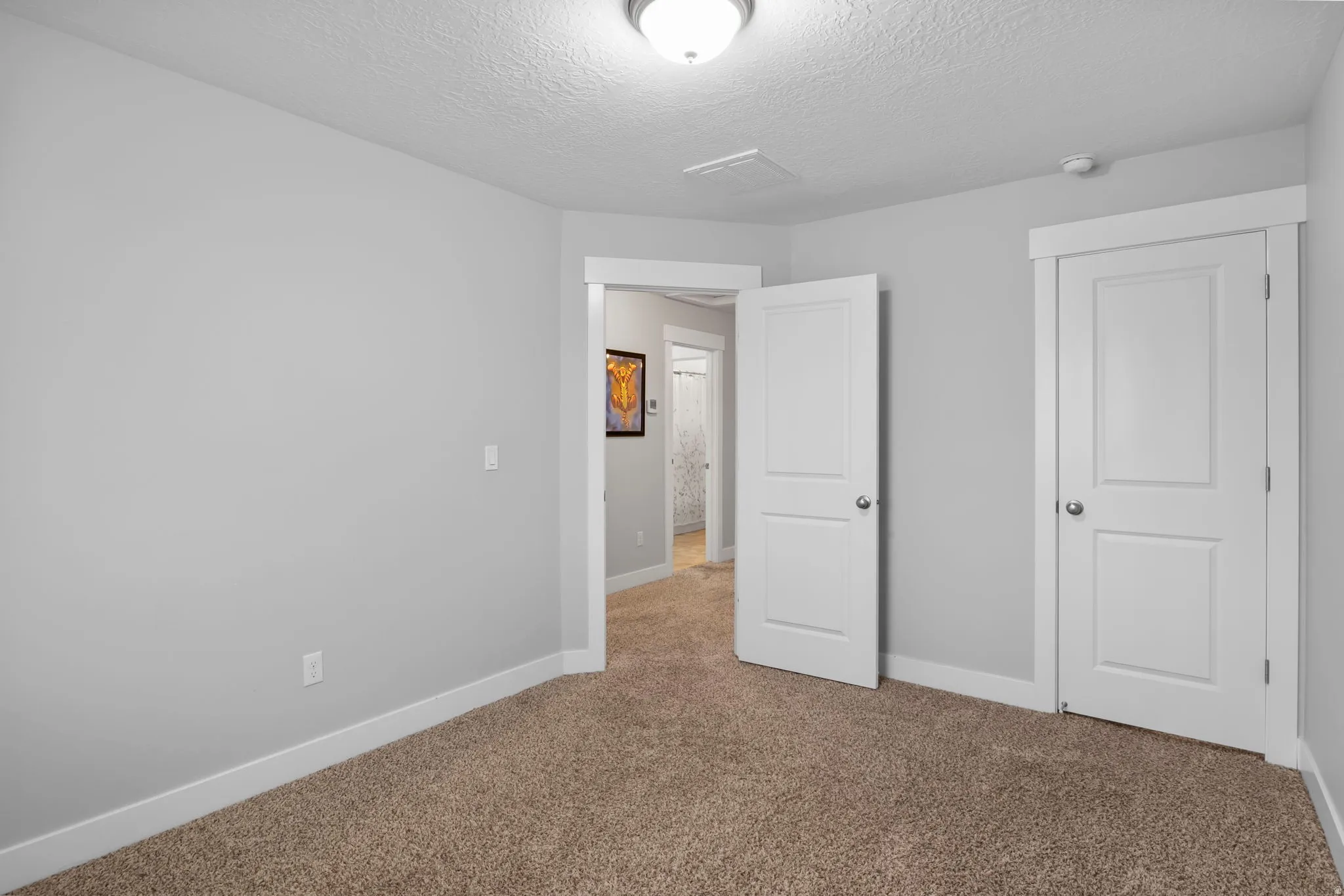 Unfurnished bedroom with carpet flooring and a textured ceiling
