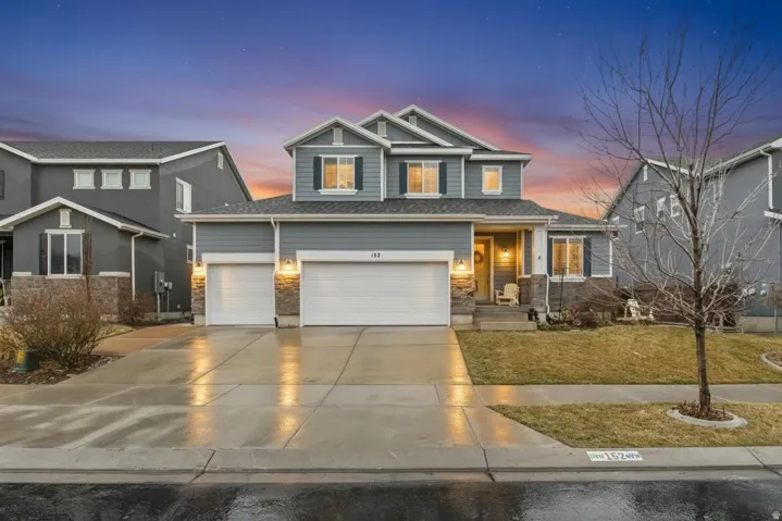 Craftsman-style home featuring driveway, a lawn, covered porch, and an attached garage
