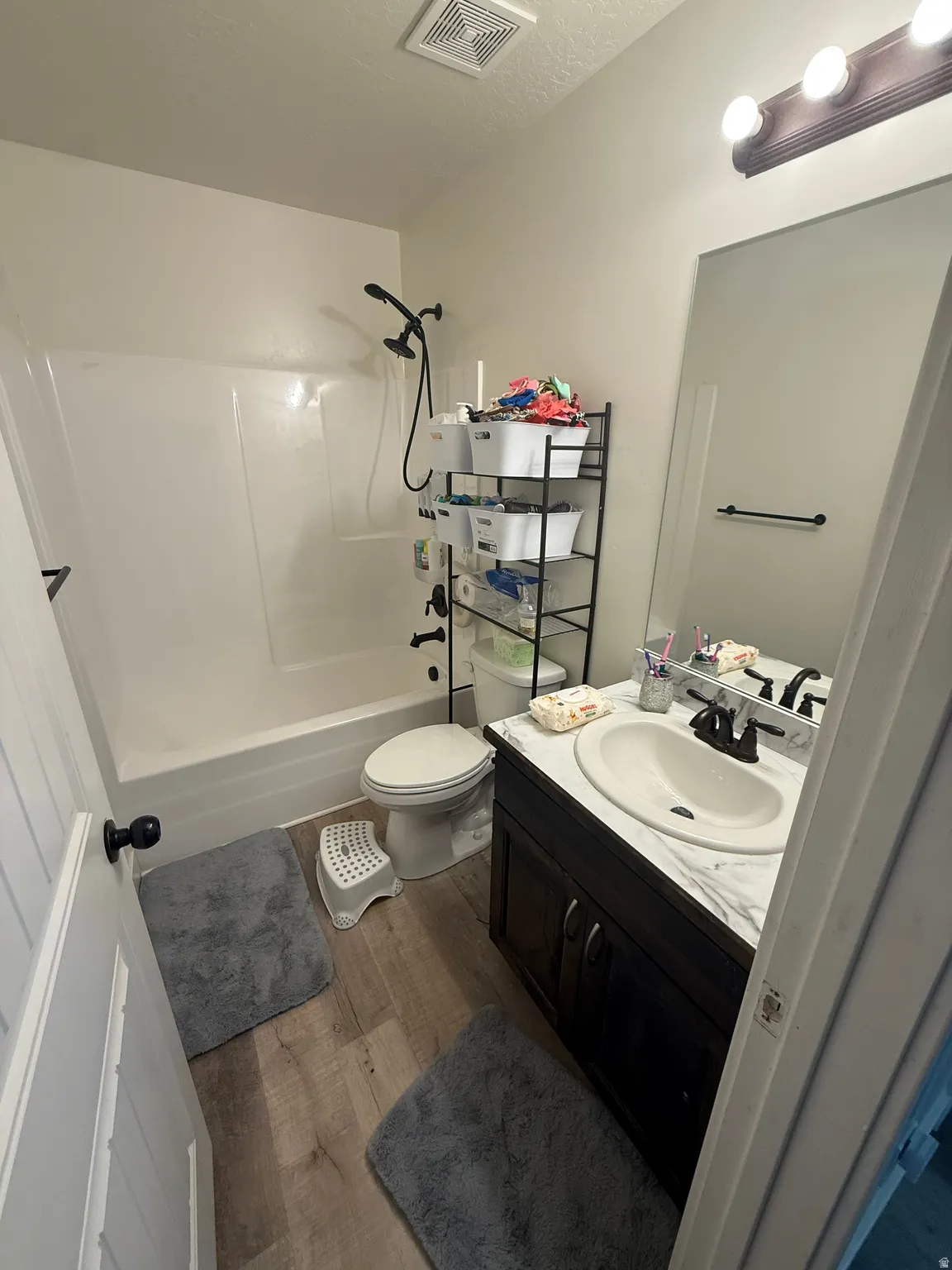 Full bathroom featuring vanity, dark wood finished floors, bathing tub / shower combination, and a textured ceiling