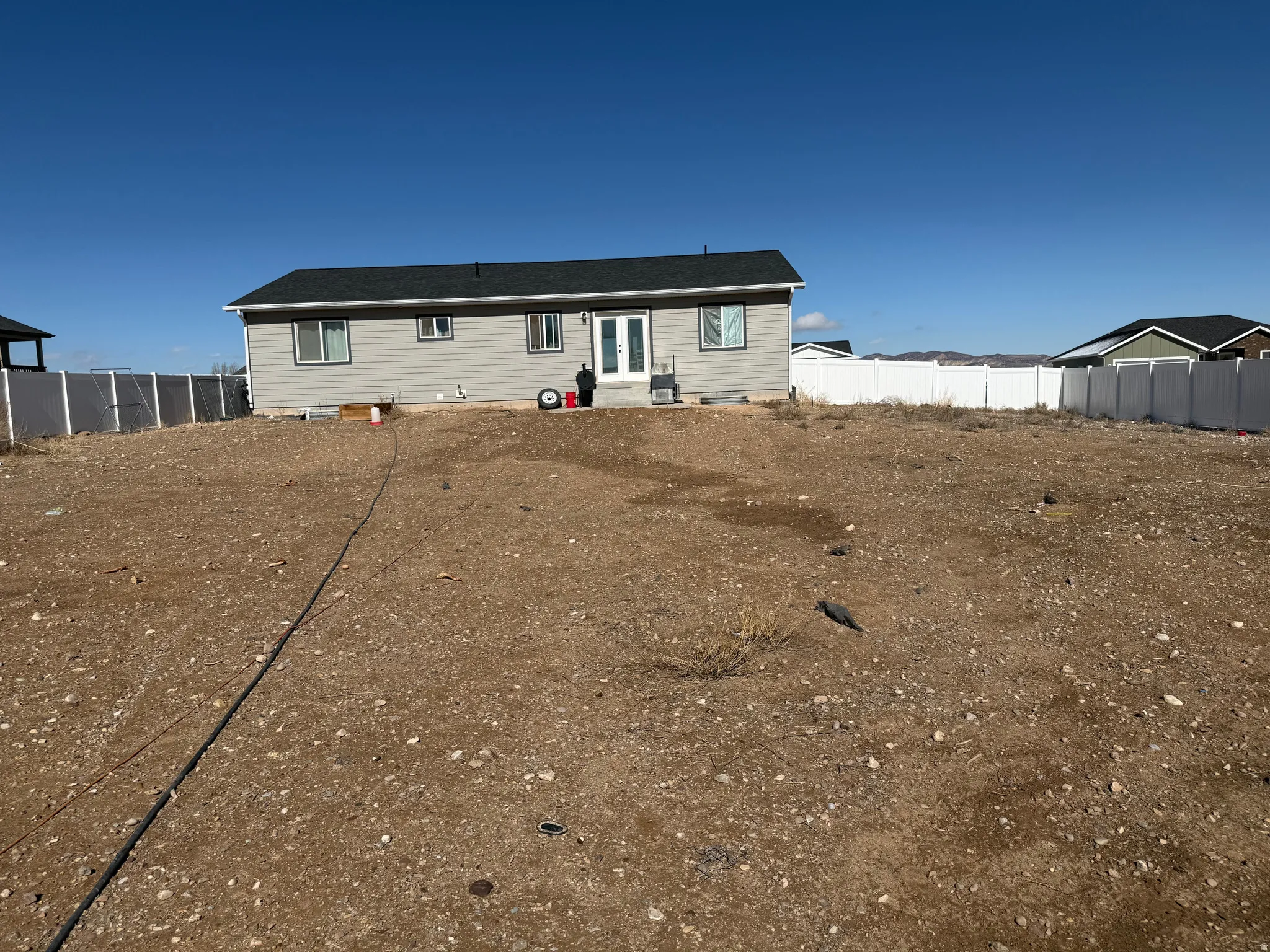 Rear view of house featuring a fenced backyard