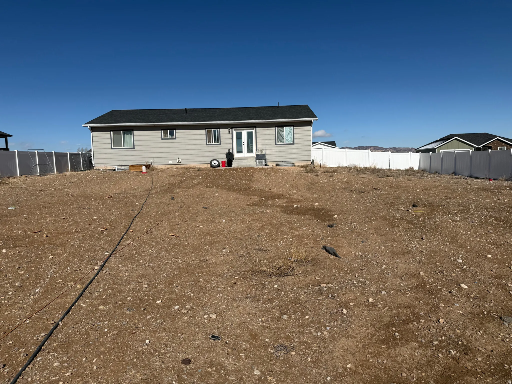 Rear view of house featuring a fenced backyard