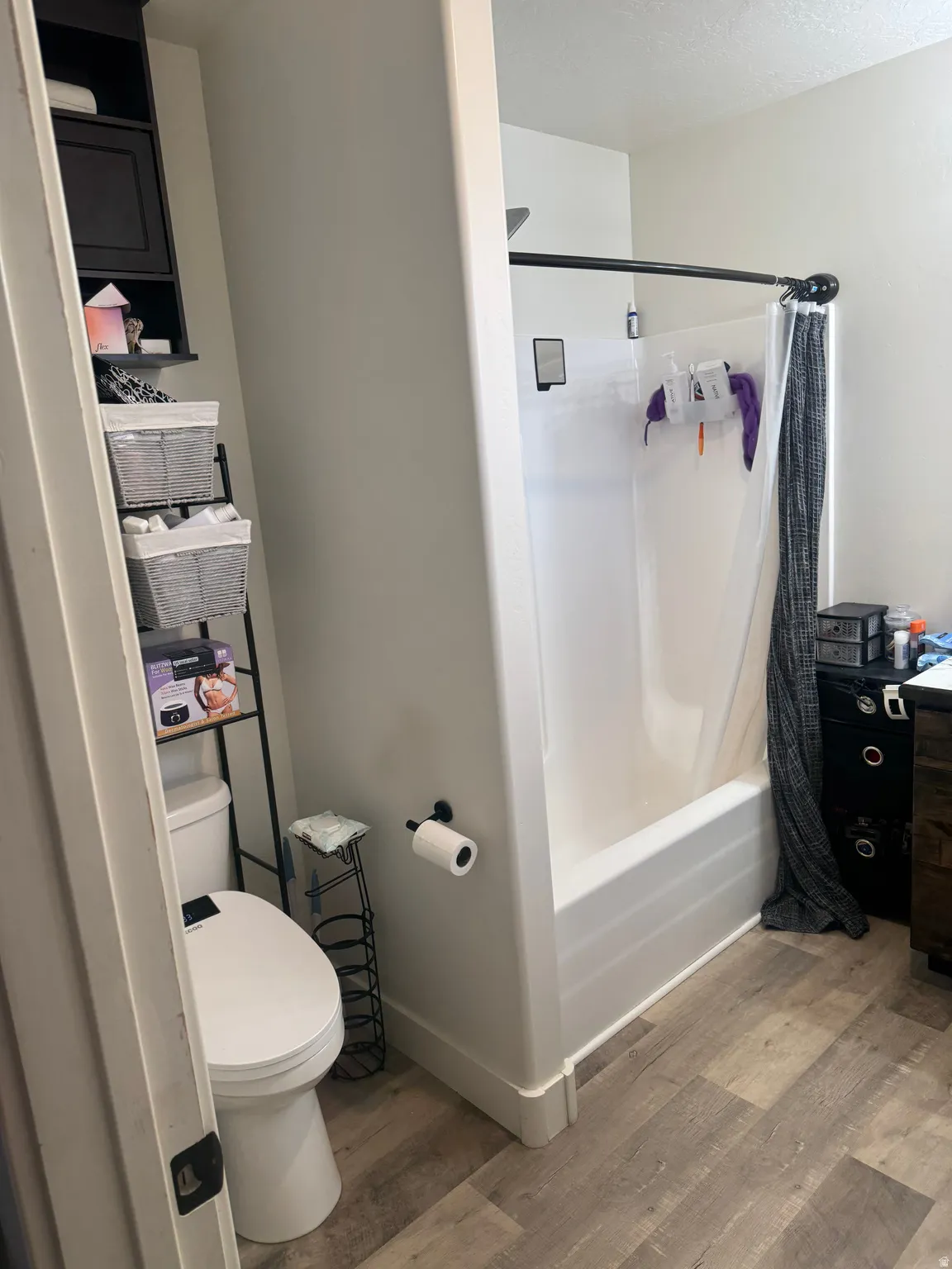 Full bathroom with light wood-type flooring, shower / bath combination with curtain, and vanity