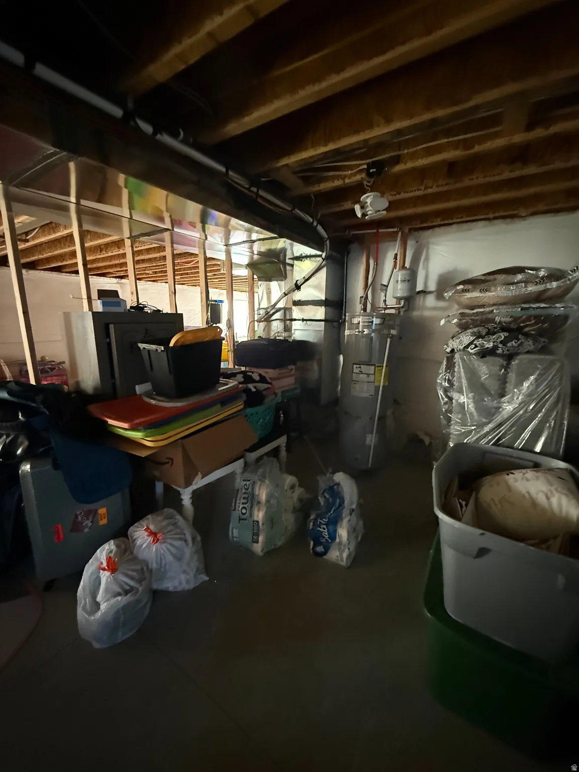 Unfinished below grade area featuring water heater