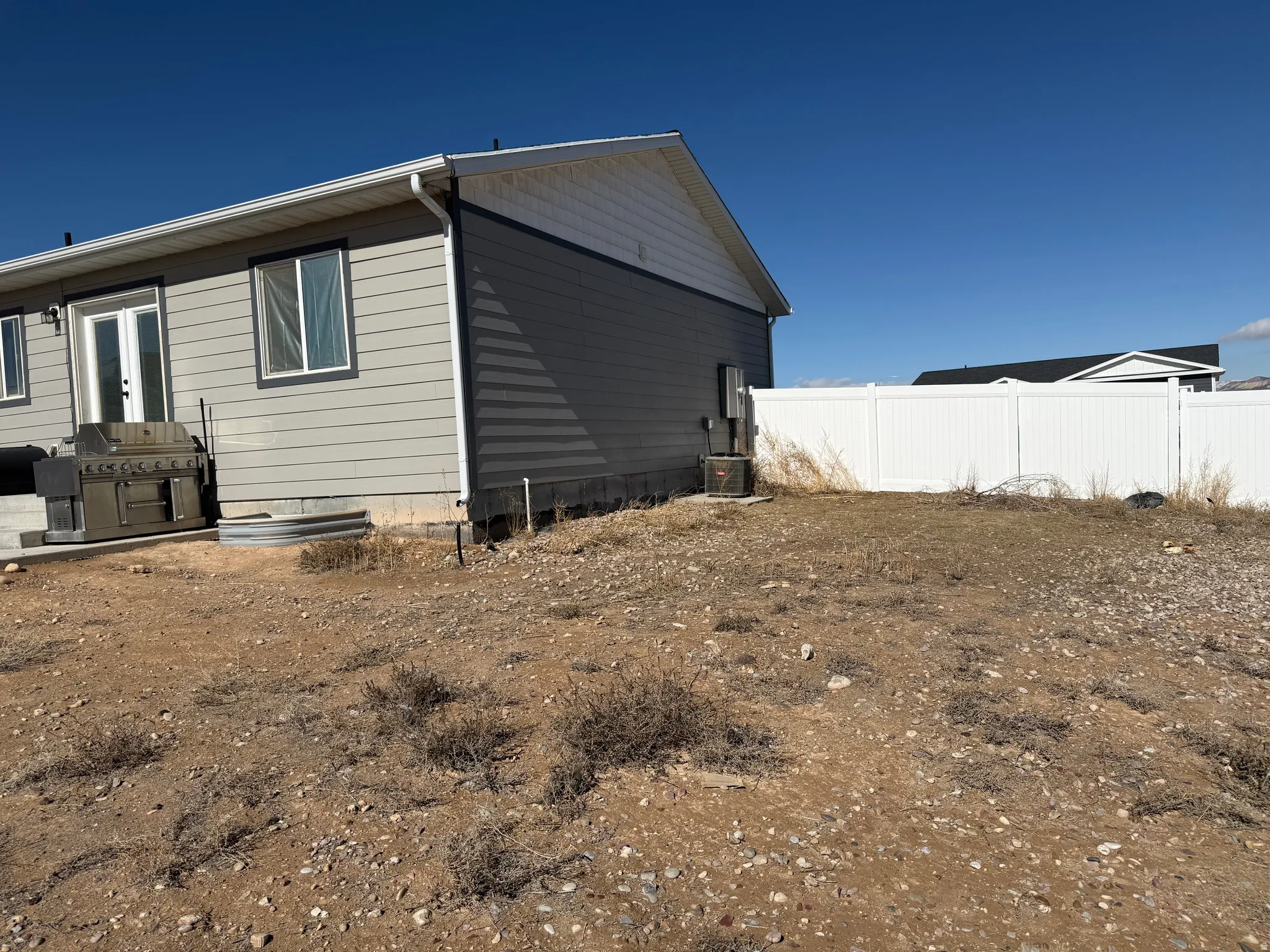View of side of home with a cooling unit and french doors