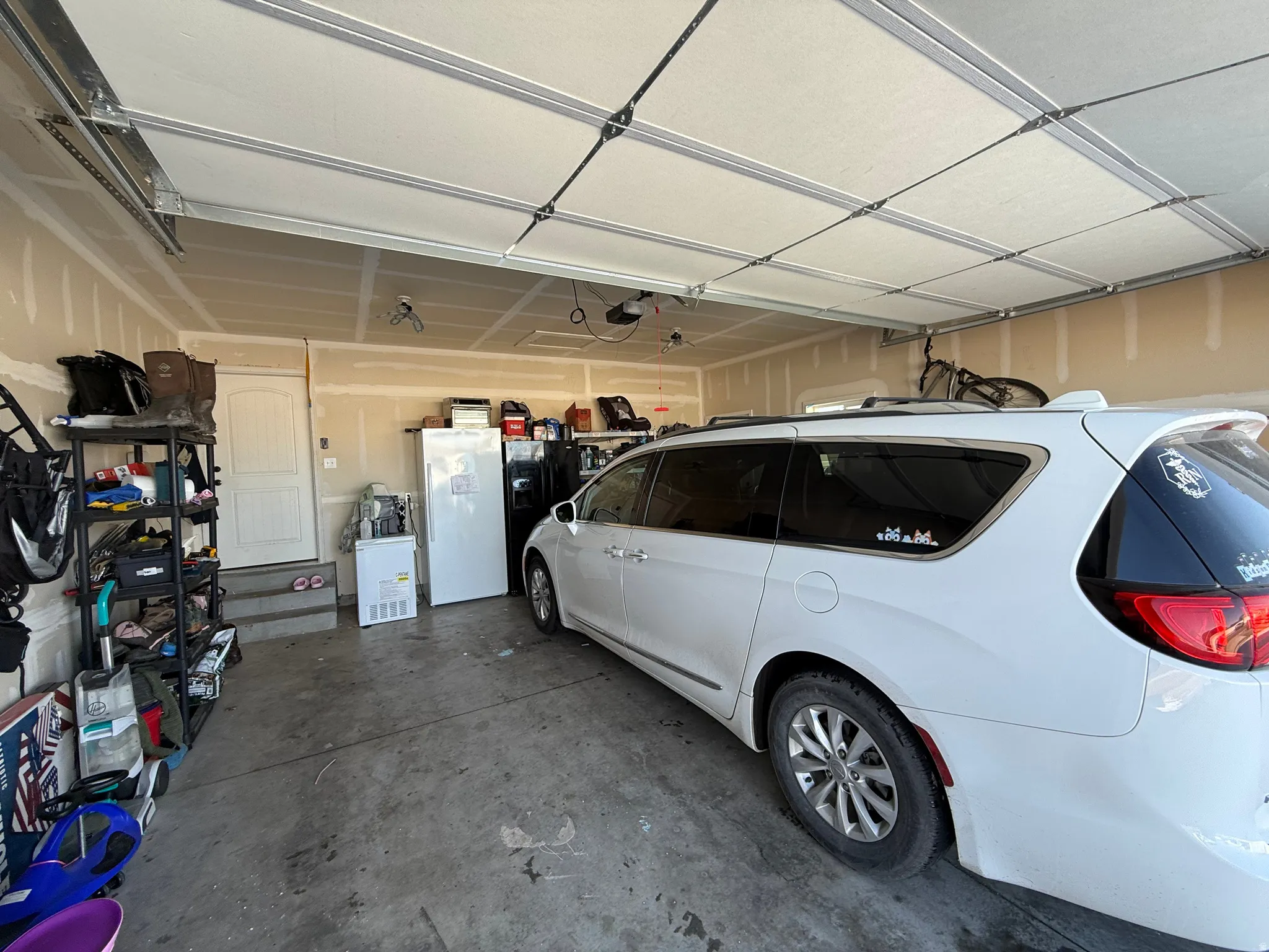 Garage featuring freestanding refrigerator