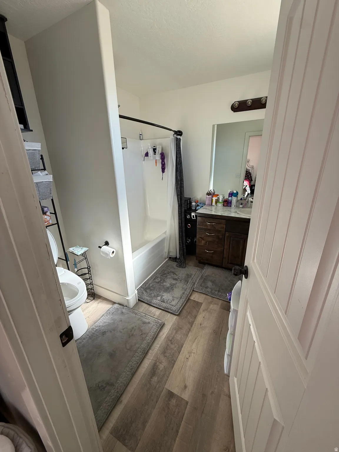Full bathroom featuring vanity, light wood finished floors, and shower / tub combo with curtain