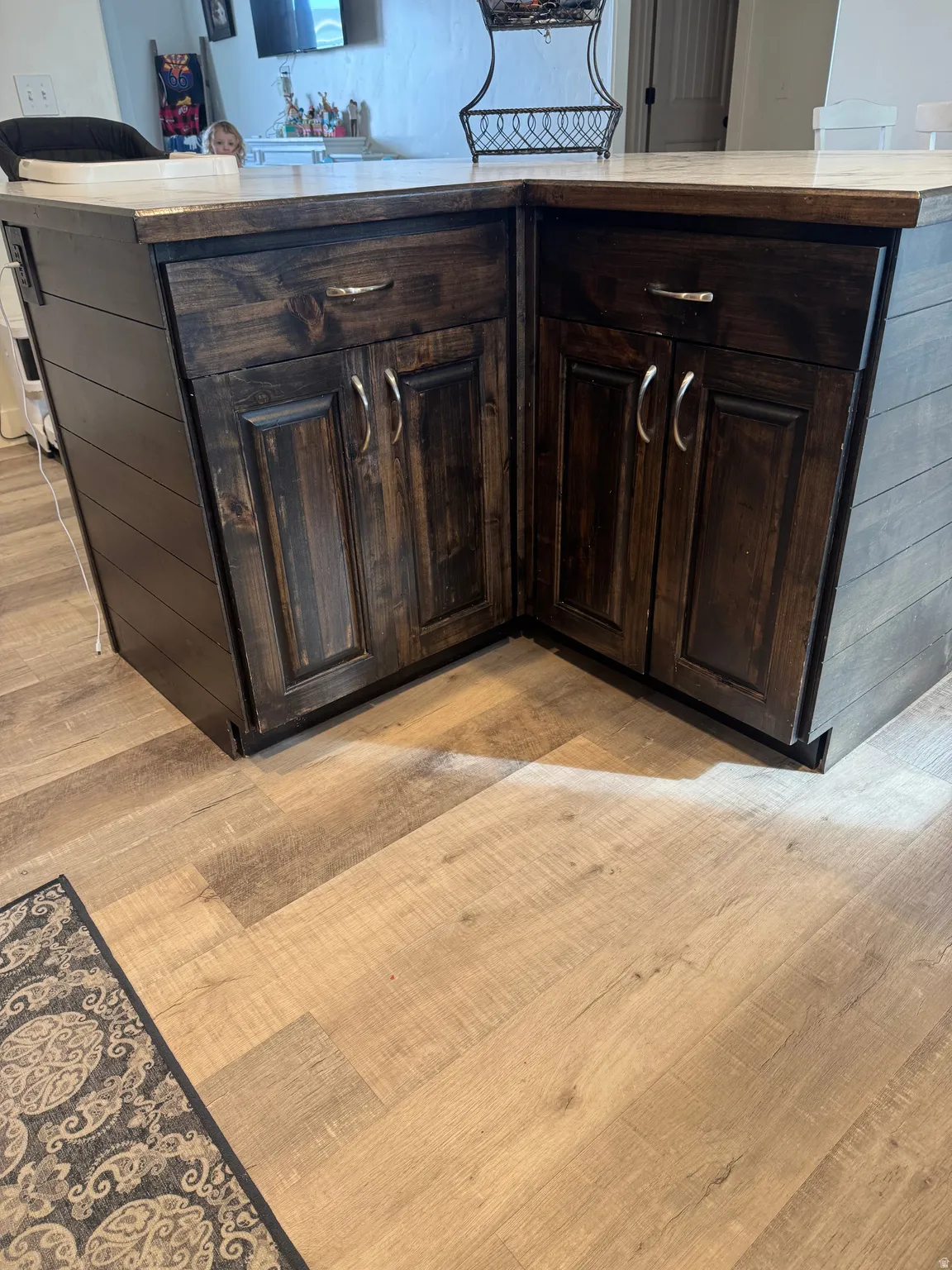 Kitchen view of dark wood finish cabinets, light wood-type flooring, and a center island