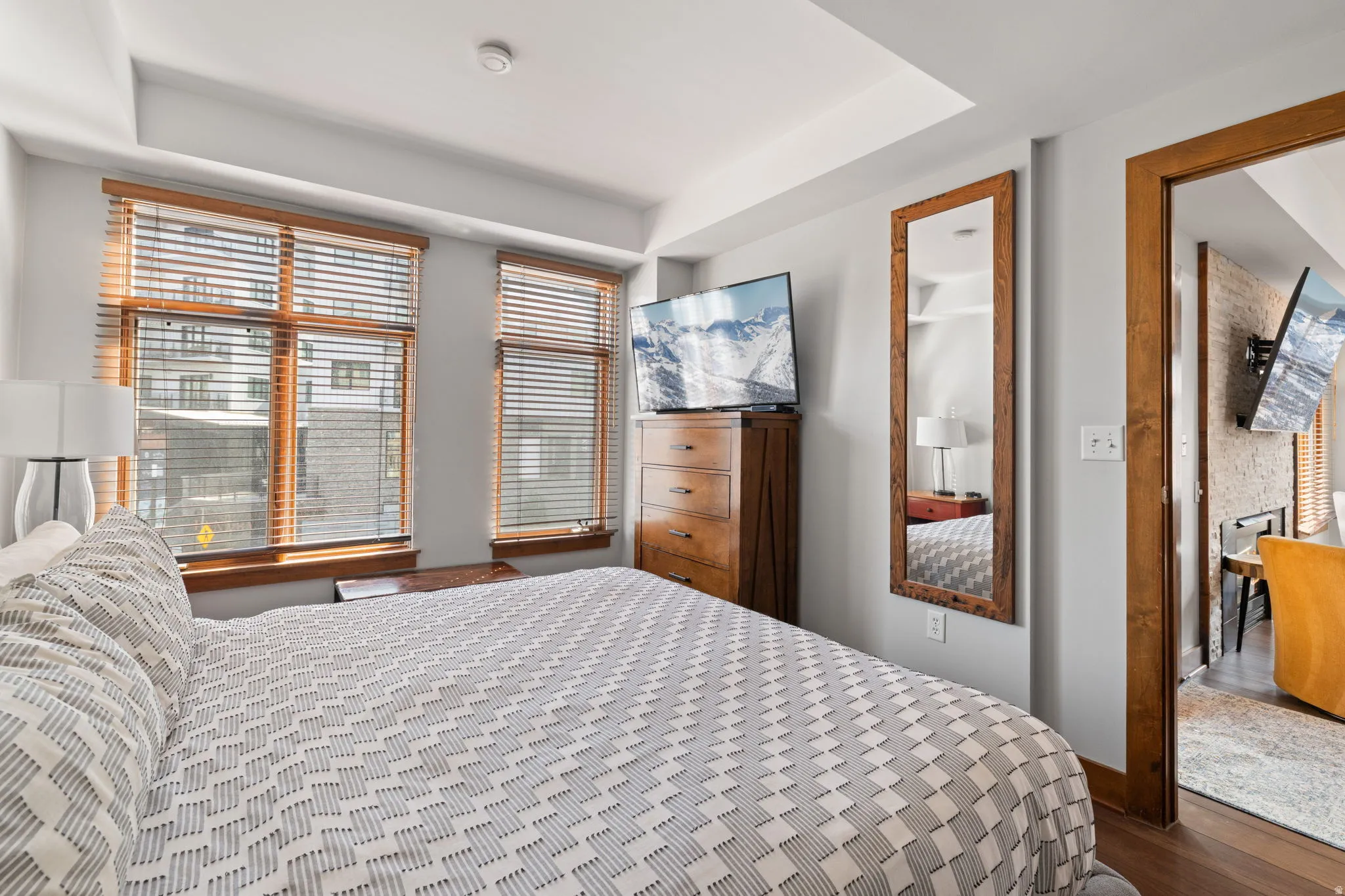 Bedroom with dark wood-style flooring and a tray ceiling