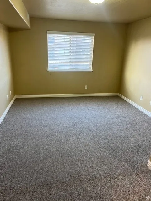 Carpeted empty room with baseboards