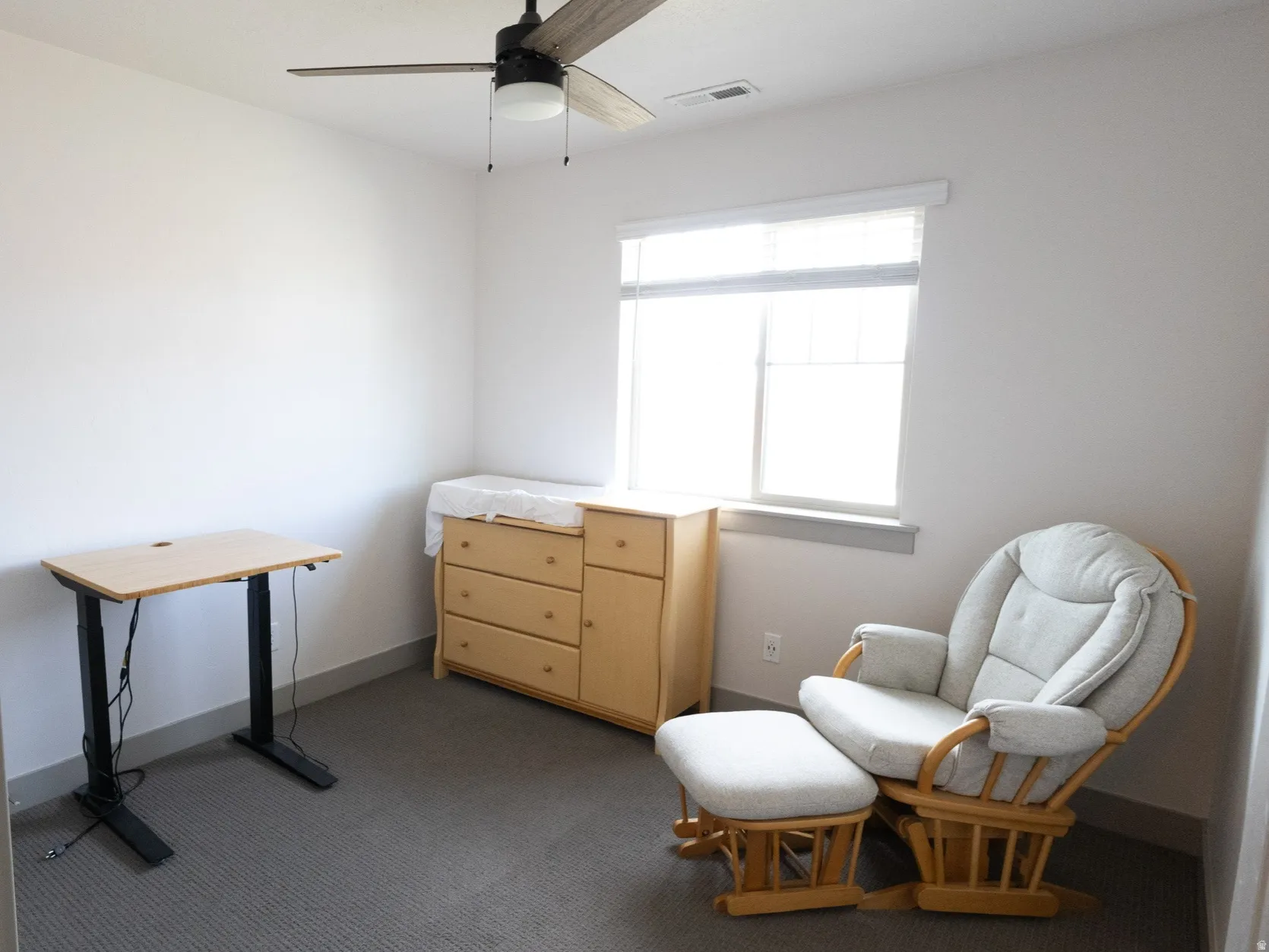 Living area with dark carpet and a ceiling fan