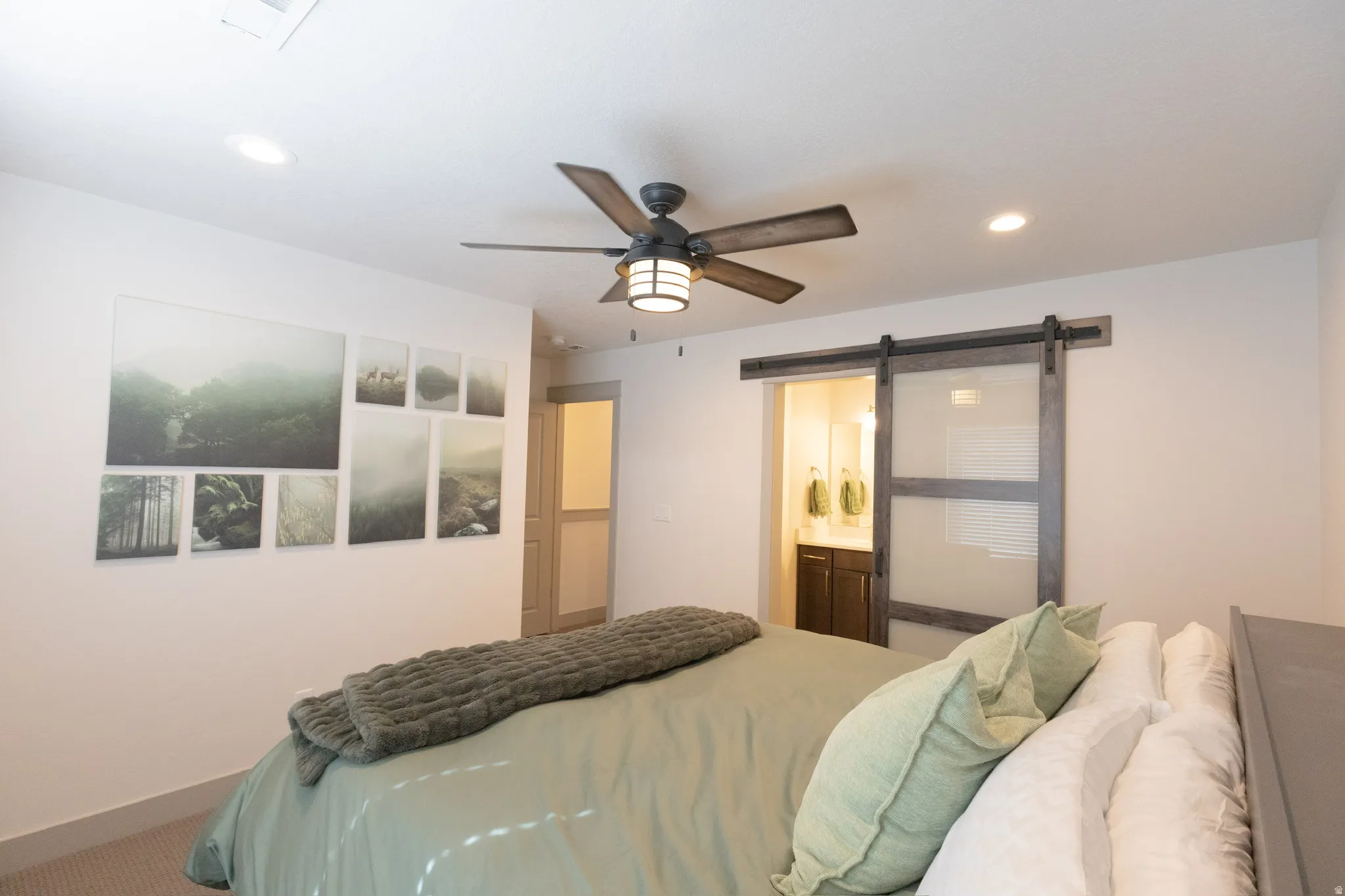 Bedroom featuring a barn door, ceiling fan, recessed lighting, connected bathroom, and carpet floors