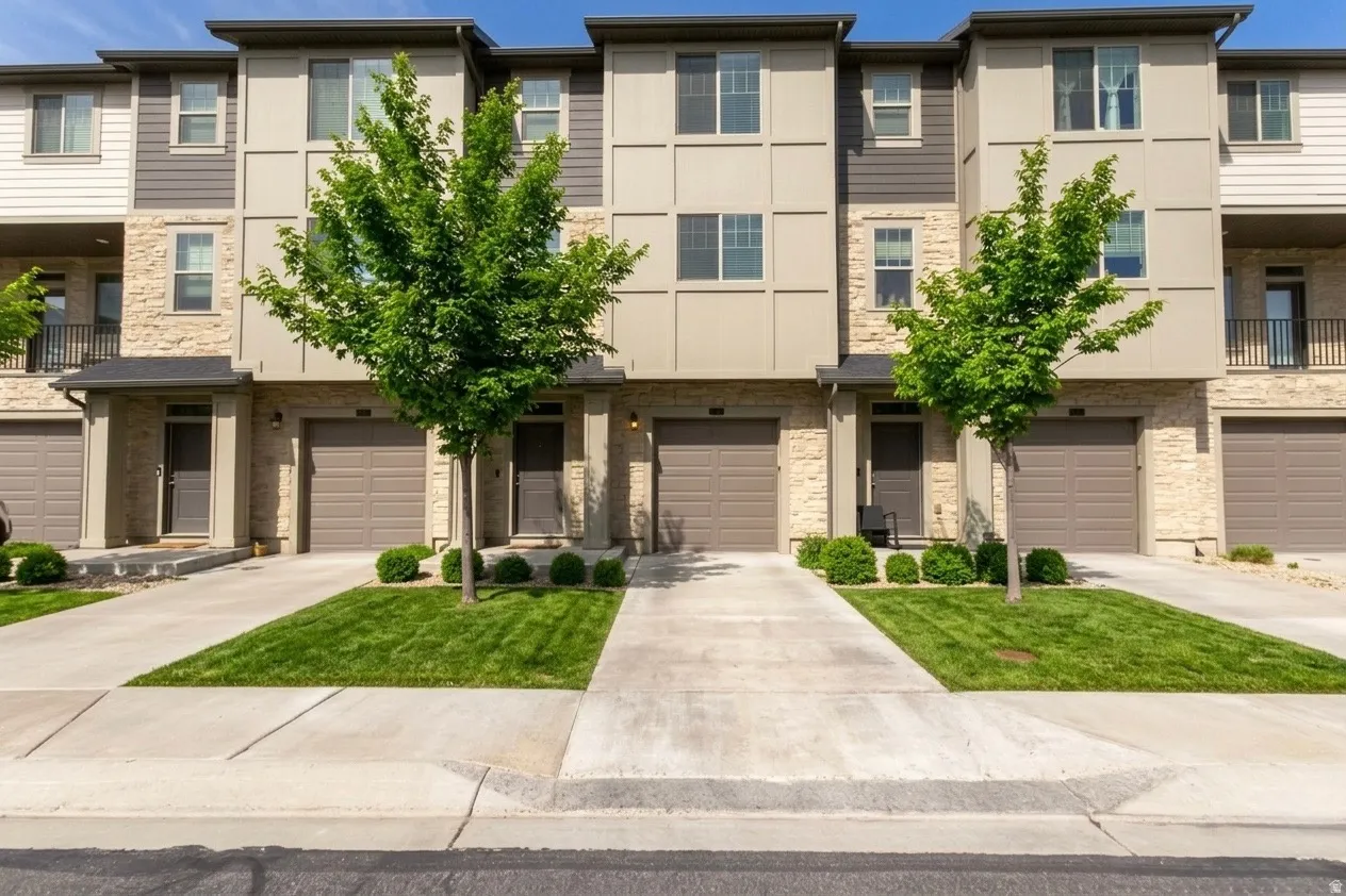 View of front of home featuring a balcony, driveway, and a garage