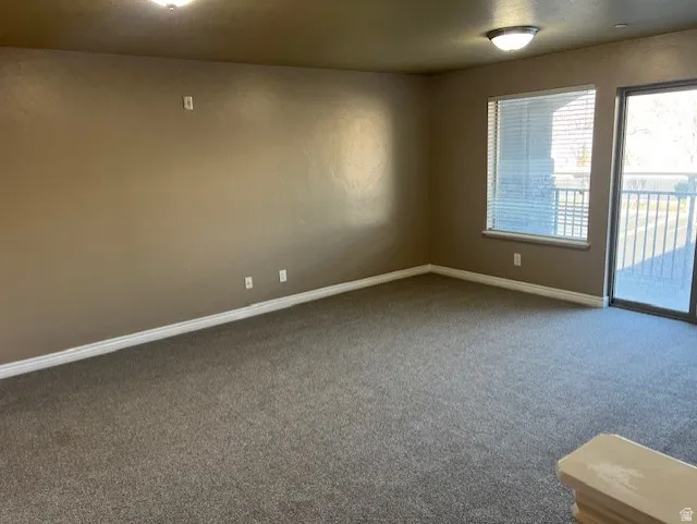 Empty room featuring carpet flooring and baseboards