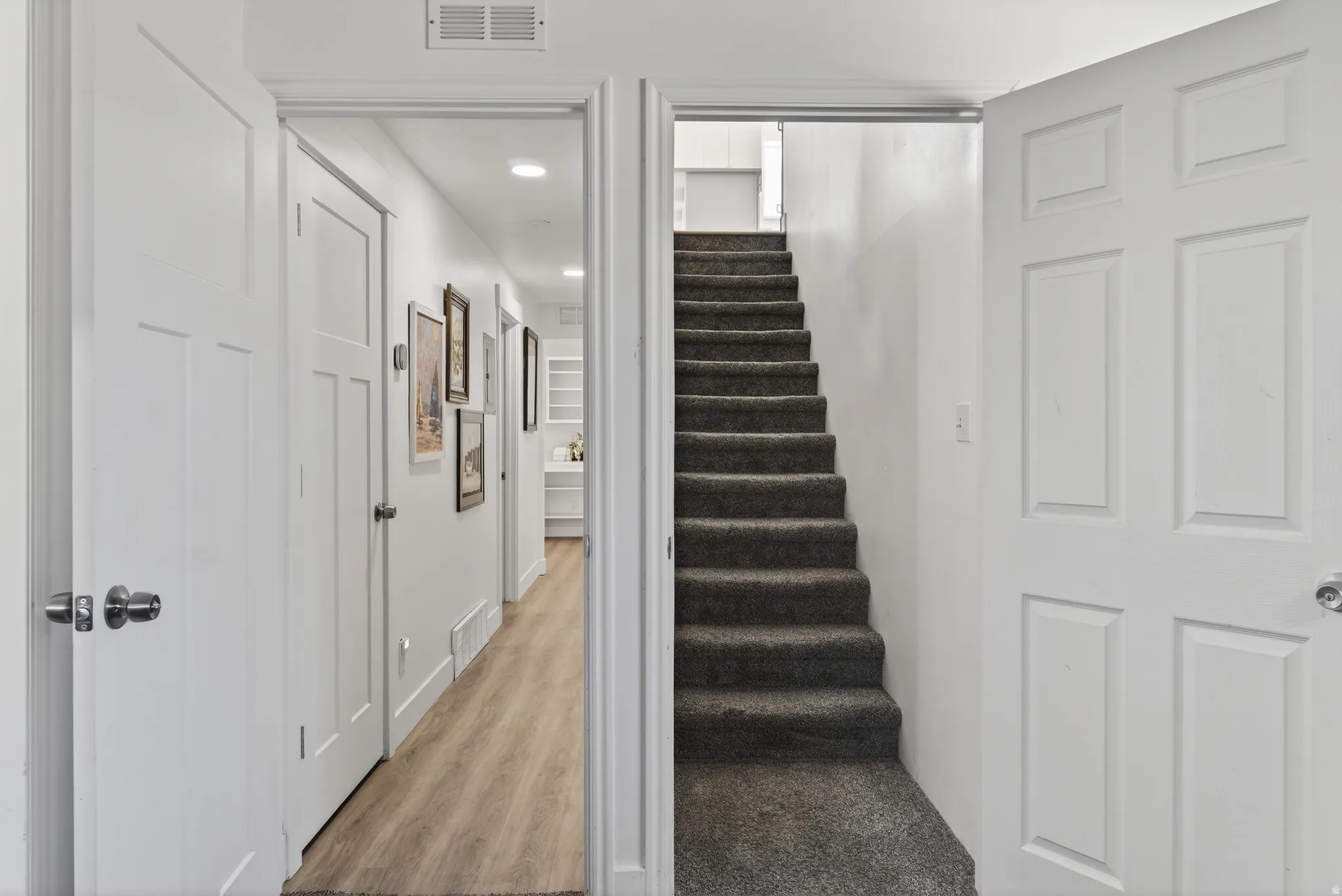Stairway with wood finished floors and recessed lighting