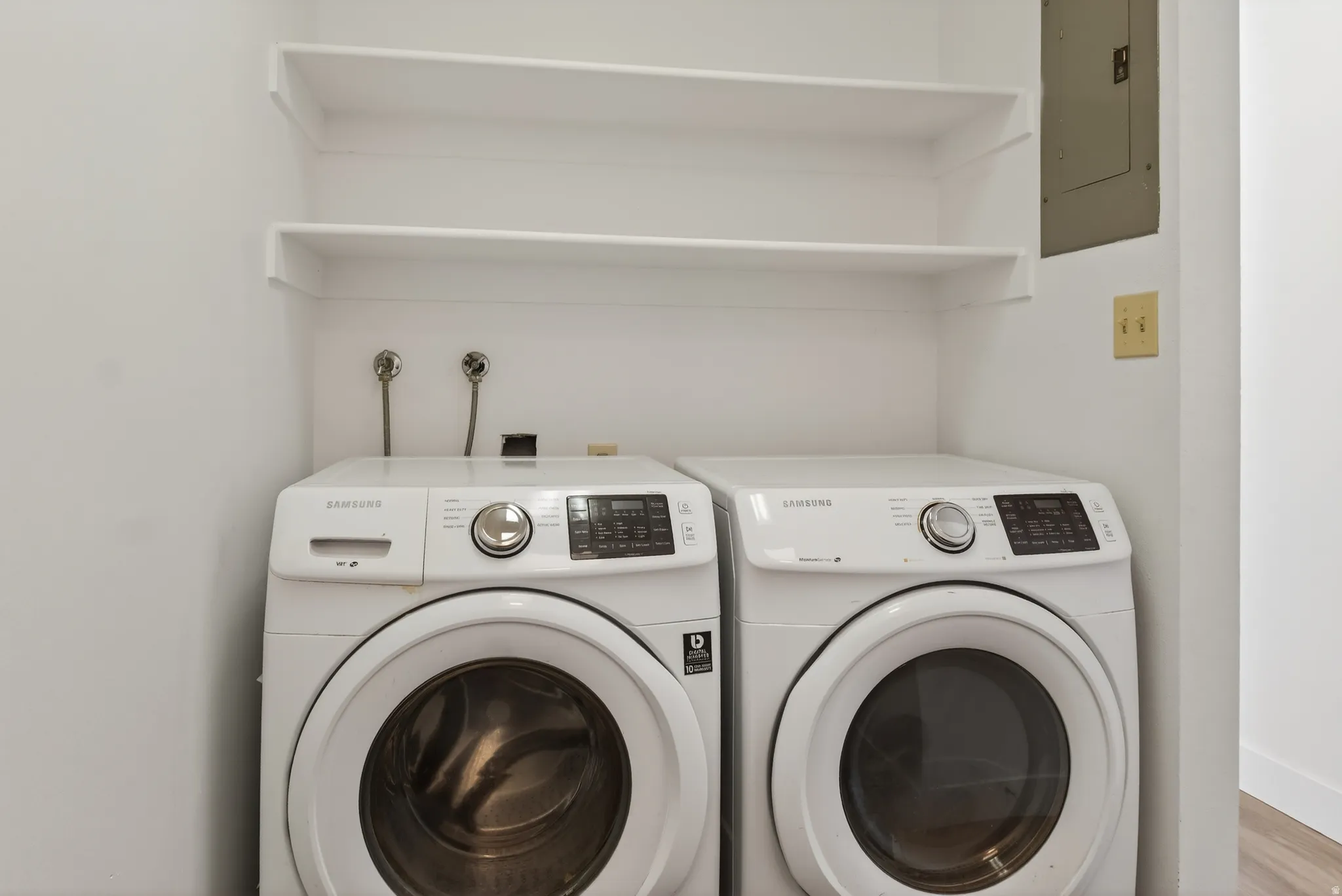 Laundry area with electric panel and washing machine and dryer