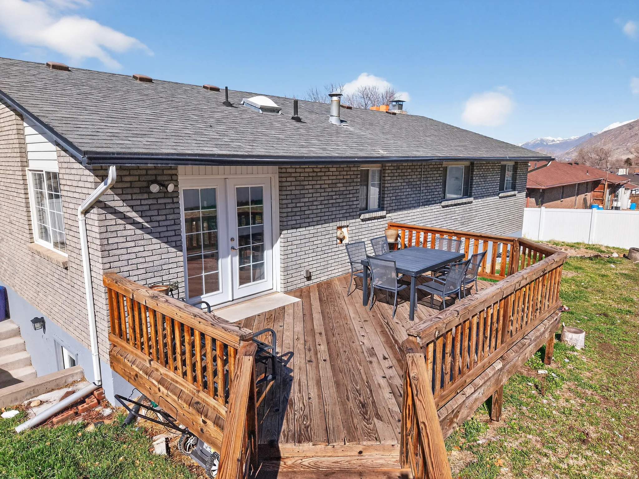 Deck with outdoor dining space, french doors, and a mountain view