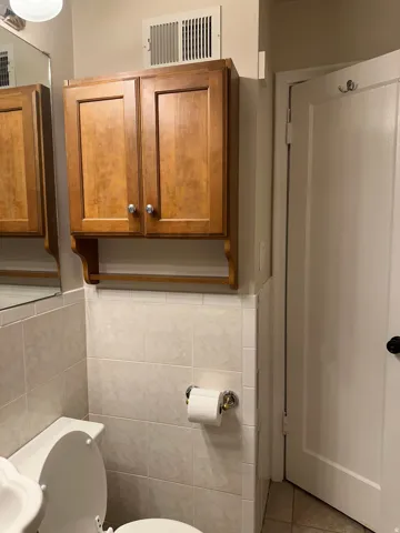 Half bathroom with light tile patterned floors and tile walls