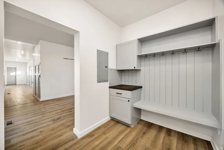 Mudroom with light wood-style floors and electric panel