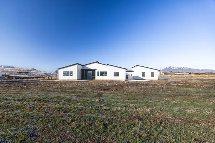 View of front of property with a mountain view and a front lawn