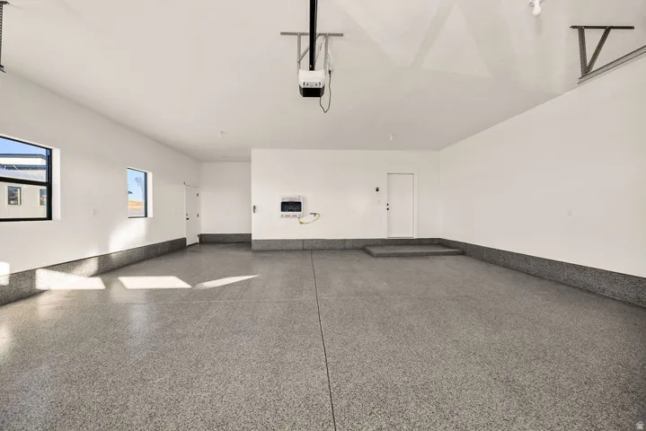 Garage with baseboards and a garage door opener