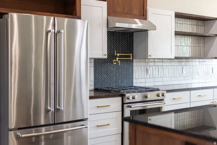 Kitchen with stainless steel appliances, white cabinetry, and open shelves