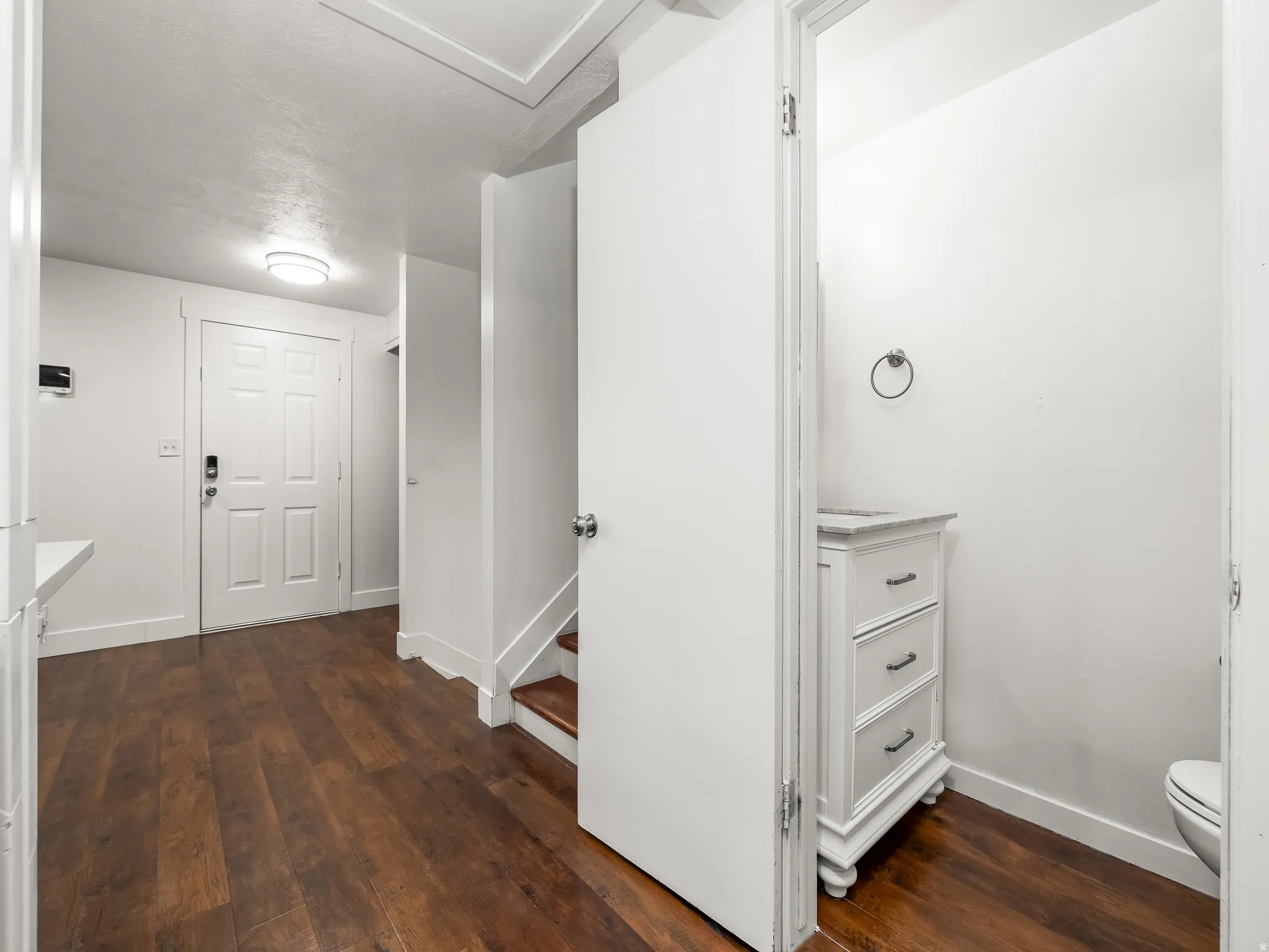Hallway featuring dark wood-type flooring and baseboards