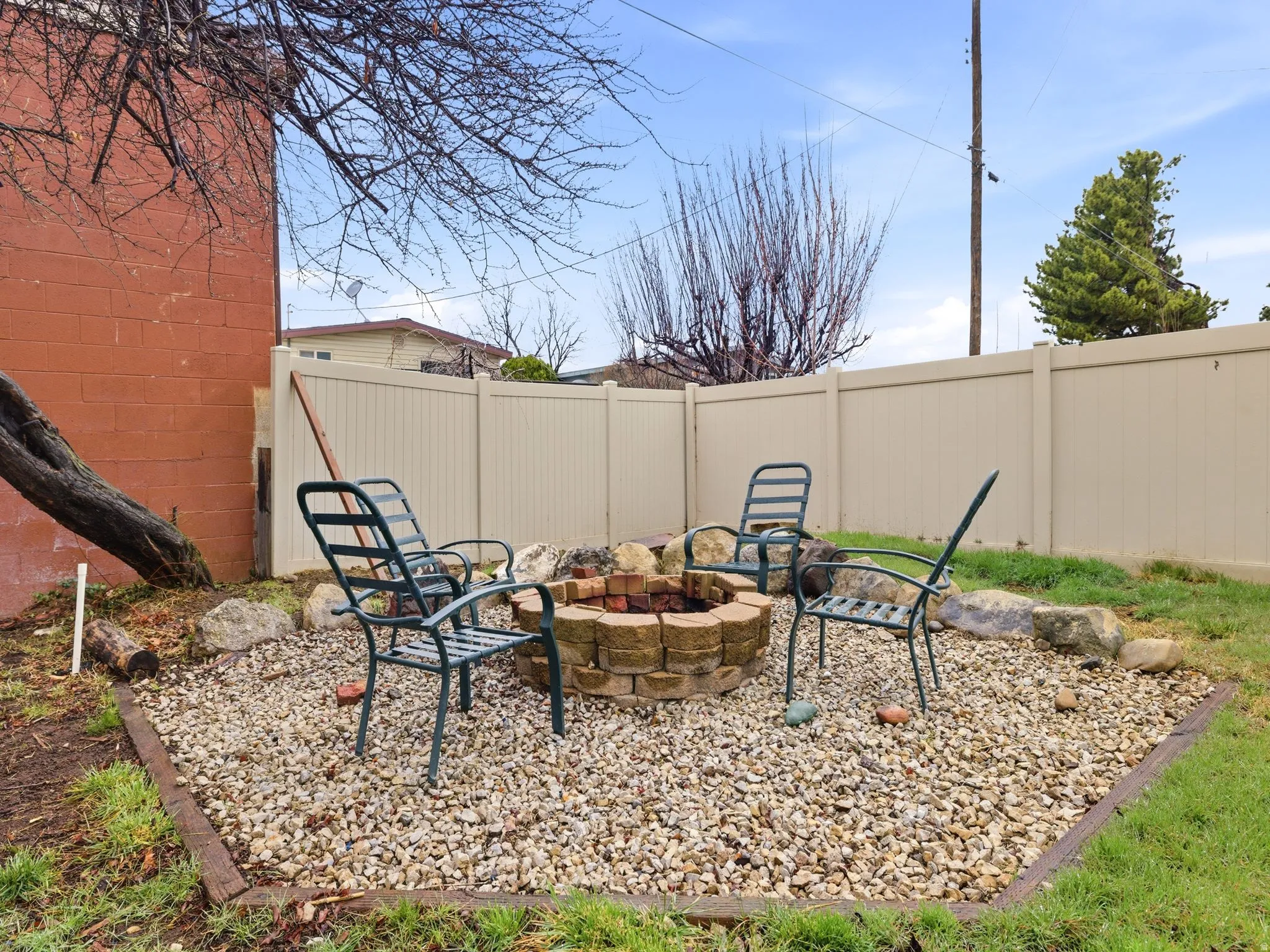 Fenced backyard featuring a fire pit and a patio