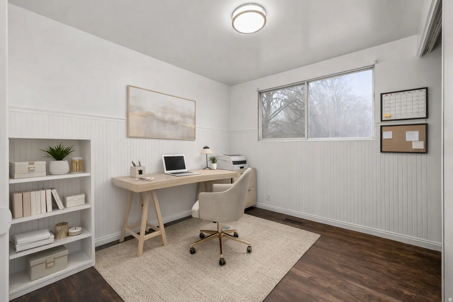 Office with dark wood-style floors and a wainscoted wall