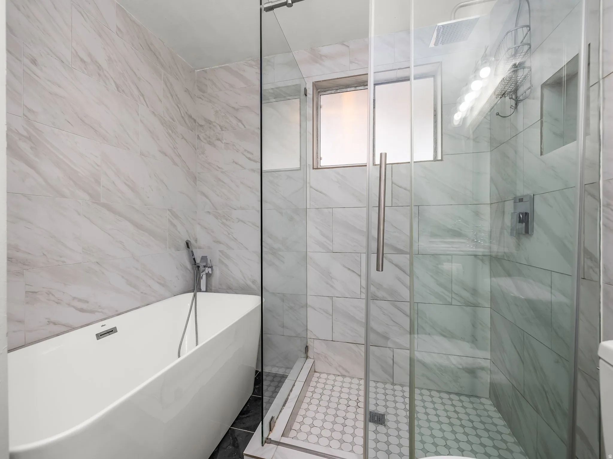 Bathroom with a soaking tub, a shower stall, and tile walls