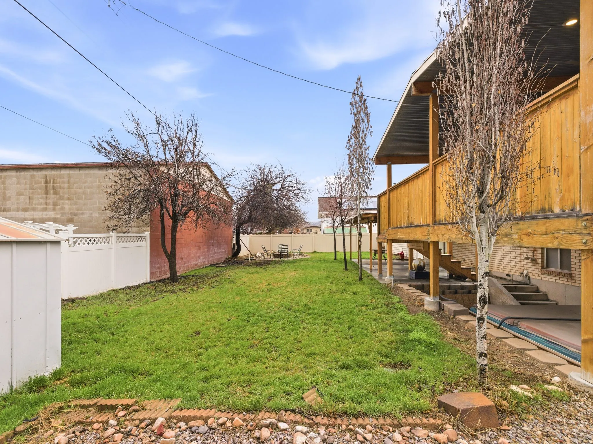 Fenced backyard featuring a deck and a patio