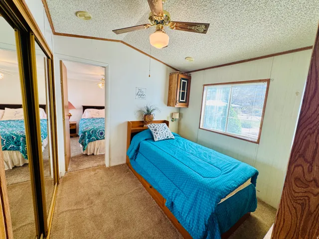 Bedroom with ornamental molding, ceiling fan, a closet, and carpet floors