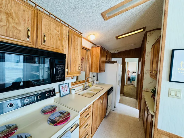 Kitchen featuring white appliances, light floors, and light countertops