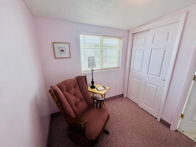 Living area with a textured ceiling and carpet floors