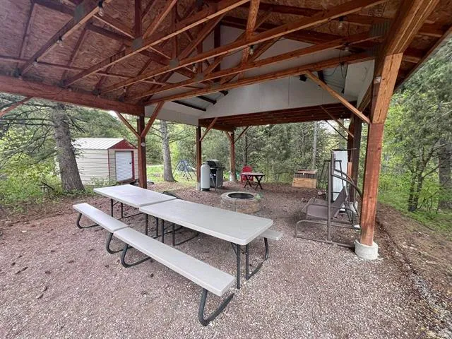View of community with a fire pit, a storage shed, and a patio area