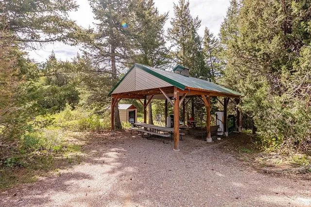 View of property's community featuring a detached carport, driveway, and a patio area