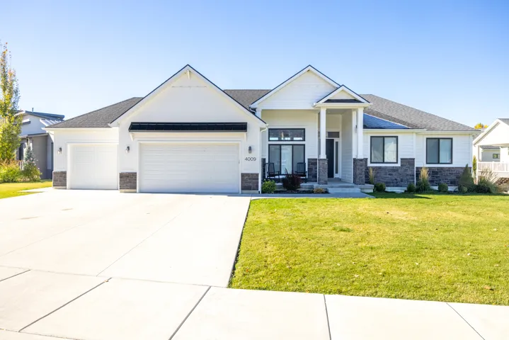 Craftsman inspired home with stone siding, an attached garage, a front yard, concrete driveway, and roof with shingles