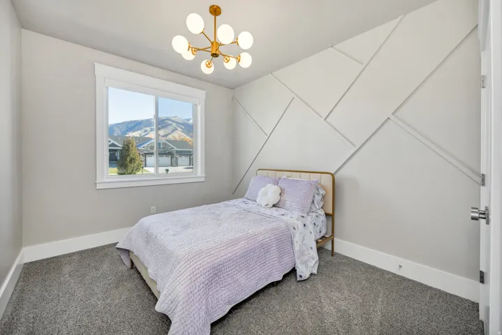 Carpeted bedroom with suspended lighting and a mountain view