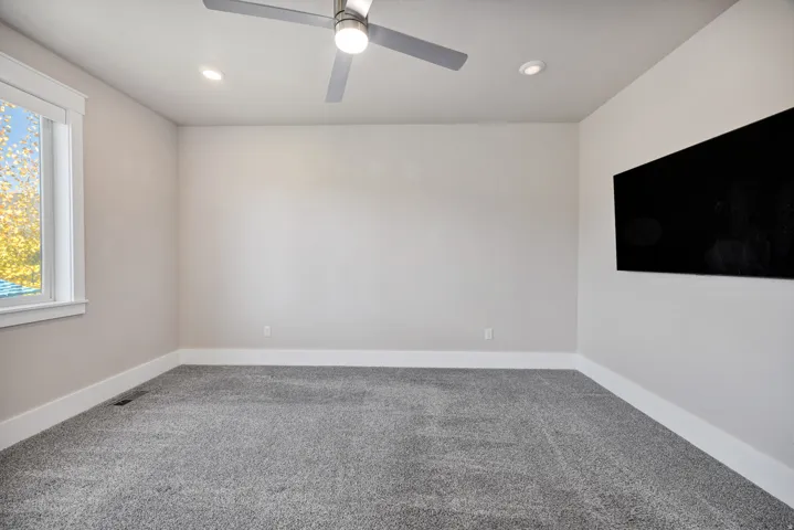 Empty room with carpet floors, a ceiling fan, and recessed lighting
