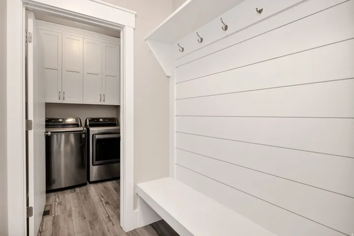 Mudroom with light wood finished floors and washer and dryer
